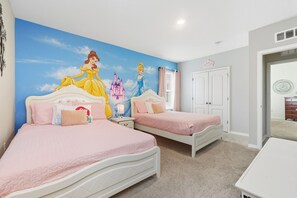 A bedroom with two beds, a mural of Disney princesses, a white wardrobe, and a door leading to another room. - Comfortably spacious home with a private pool, spa, and arcade. (Davenport)