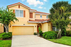 A two-story house with a beige facade, a red-tiled roof, and a single garage. - Comfortably spacious home with a private pool, spa, and arcade. (Davenport)