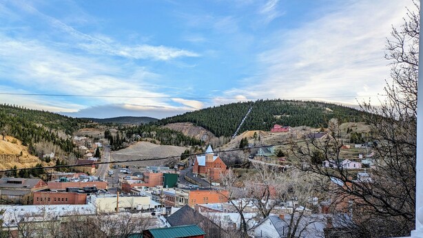 A town with buildings, a church, and a hill in the background.