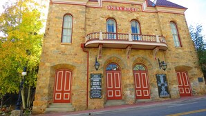 A stone building with a balcony and a sign reading "Opera House".