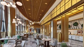 Un'ampia hall dell'hotel con soffitti alti, lampadari moderni e pavimento in marmo.