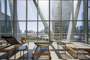 Relax in style with expansive city views from the lounge area, featuring sun loungers and a small table.