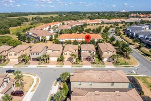 Houses with red-tiled roofs and palm trees line the streets in this residential area.