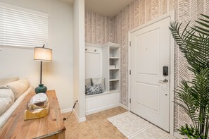 Enter a serene space with a comfortable bench and a stylish nightstand, featuring a lamp and decorative piece.