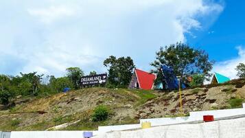 A hilly landscape with a sign for 'Dreamland Beach Holiday' and colorful buildings.