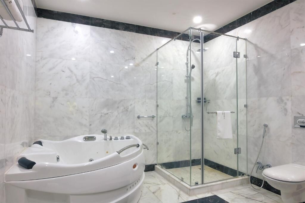 A modern bathroom with a glass-enclosed shower, a standalone bathtub, and a toilet.