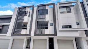 A modern multi-story residential building with a clean, minimalist design, featuring large windows and a flat roof. - Modern, chic 3BR townhouse in luxury complex, top location, free wifi (Bulimba)