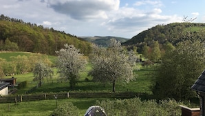 A rural landscape with green fields, trees, and a clear sky. - Gasthof Feische (Sundern)