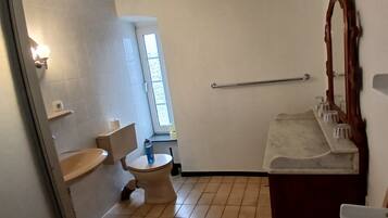 Une salle de bain avec des toilettes, un lavabo et un miroir.