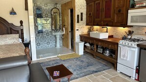 A compact kitchen with wooden cabinets, a white stove, and a sink. - Wilderness Country Inn: Italy (Mentone)