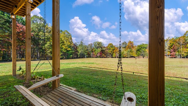 A wooden swing set in a park with a clear sky and autumn trees in the background. - Wilderness Country Inn: Italy (Mentone)