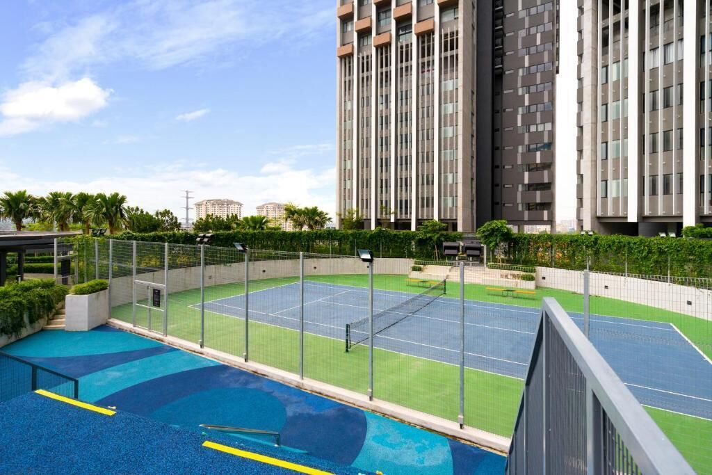 Un complejo residencial con cancha de tenis, piscina y edificios altos.