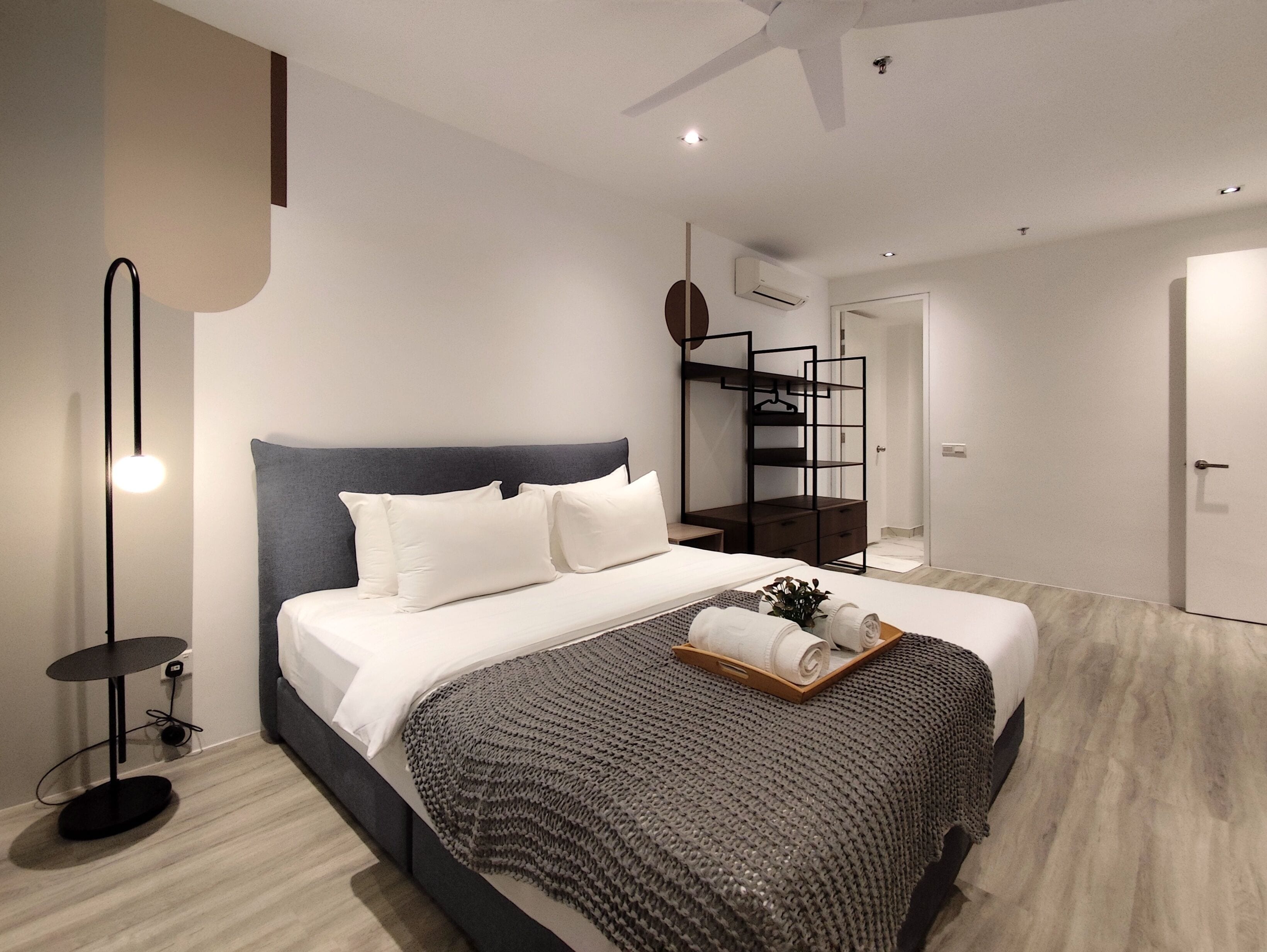 A modern bedroom with a bed, bedside table, and a built-in wardrobe.
