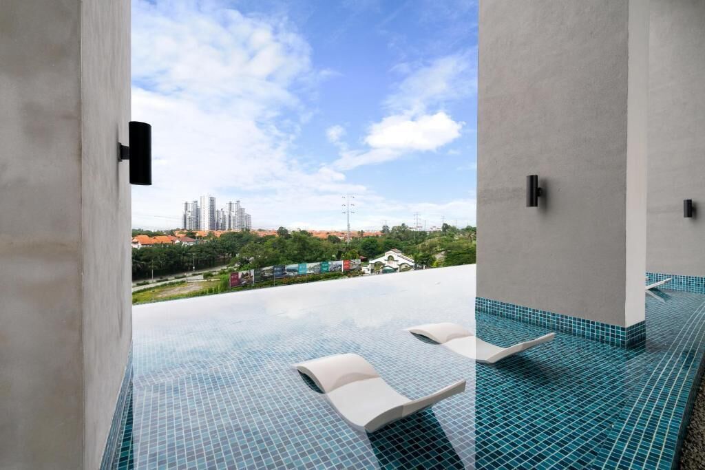 Une piscine à débordement située sur le toit, avec des chaises longues, une vue dégagée sur le paysage urbain et un sol carrelé.