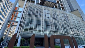 A modern high-rise building with a prominent entrance and a large sign. - Lumi Tropicana (Petaling Jaya)
