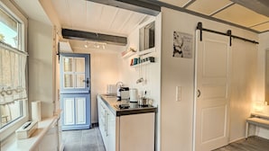 A kitchen with a blue door, a white cabinet, and a black countertop. - fewo1846 - "Unsere Blume" / charming 2 room apartment with balcony / harbor view (Flensburg)