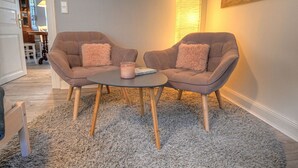 A cozy seating area with two armchairs and a small round table, featuring a fluffy pillow and a candle. - fewo1846 - "Unsere Blume" / charming 2 room apartment with balcony / harbor view (Flensburg)