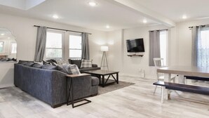 A modern living room with a sofa, coffee table, and dining table. - BRAND NEW LISTING - Northside Cottage (Hendersonville)