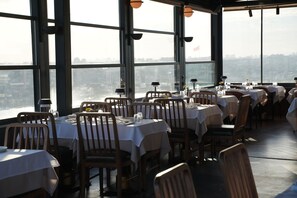 A restaurant with tables set for dining, large windows, and a view of the cityscape. - Ring Stone Hotels Bosphorus (Istanbul)