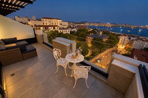 A rooftop terrace with a table and chairs, overlooking a cityscape and a body of water. - Ring Stone Hotels Bosphorus (Istanbul)