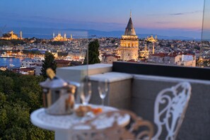 A balcony with a table and chairs overlooking a cityscape with historic buildings and a view of the sea. - Ring Stone Hotels Bosphorus (Istanbul)