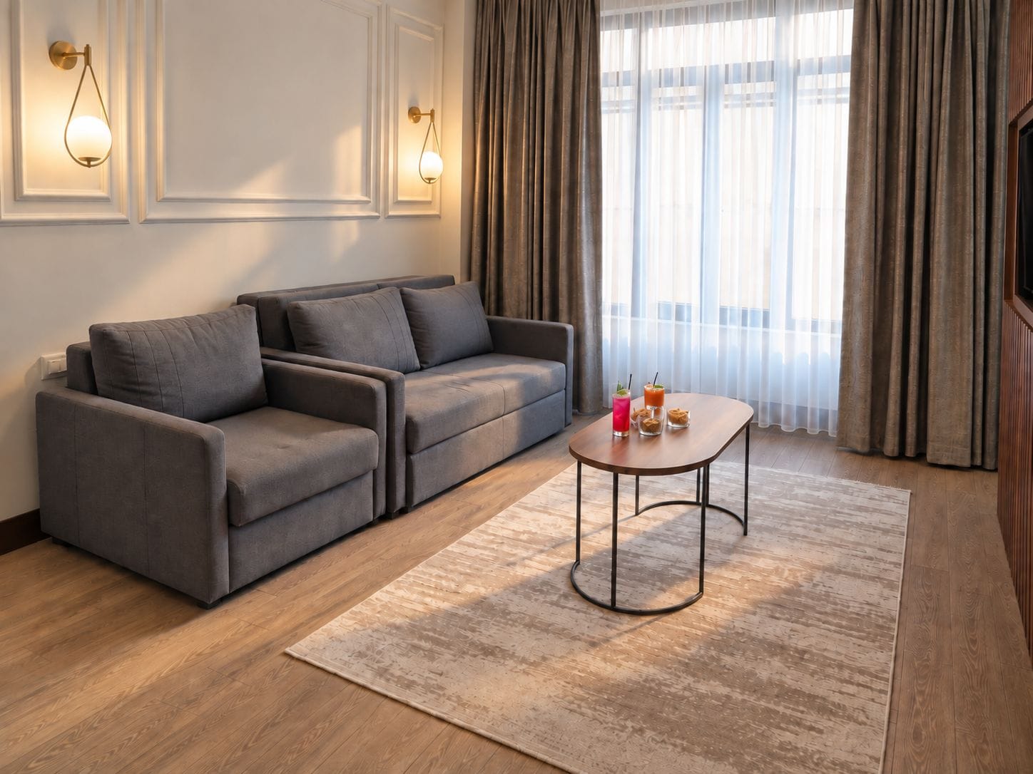 Un salon moderne avec un canapé gris, une table basse en bois et un tapis à motifs.