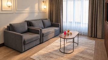 Un salon moderne avec un canapé gris, une table basse en bois et un tapis à motifs.