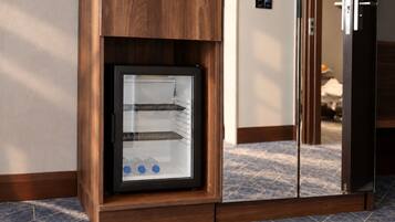 A modern kitchen with a built-in refrigerator, wooden cabinetry, and a tiled floor.
