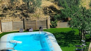 A rectangular inflatable pool with a white cover, surrounded by a well-maintained lawn and a wooden fence. - Country house with pool sea view (camporosso)