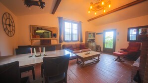 A spacious living area with a dining table, chairs, a sofa, and a red armchair. There is a large mirror, a chandelier, and a clock on the wall. - Country house with pool sea view (camporosso)