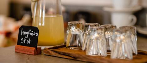 Un présentoir à boissons avec une pancarte indiquant « Inglera Shot » et plusieurs petits verres à shooter disposés sur un plateau en bois.