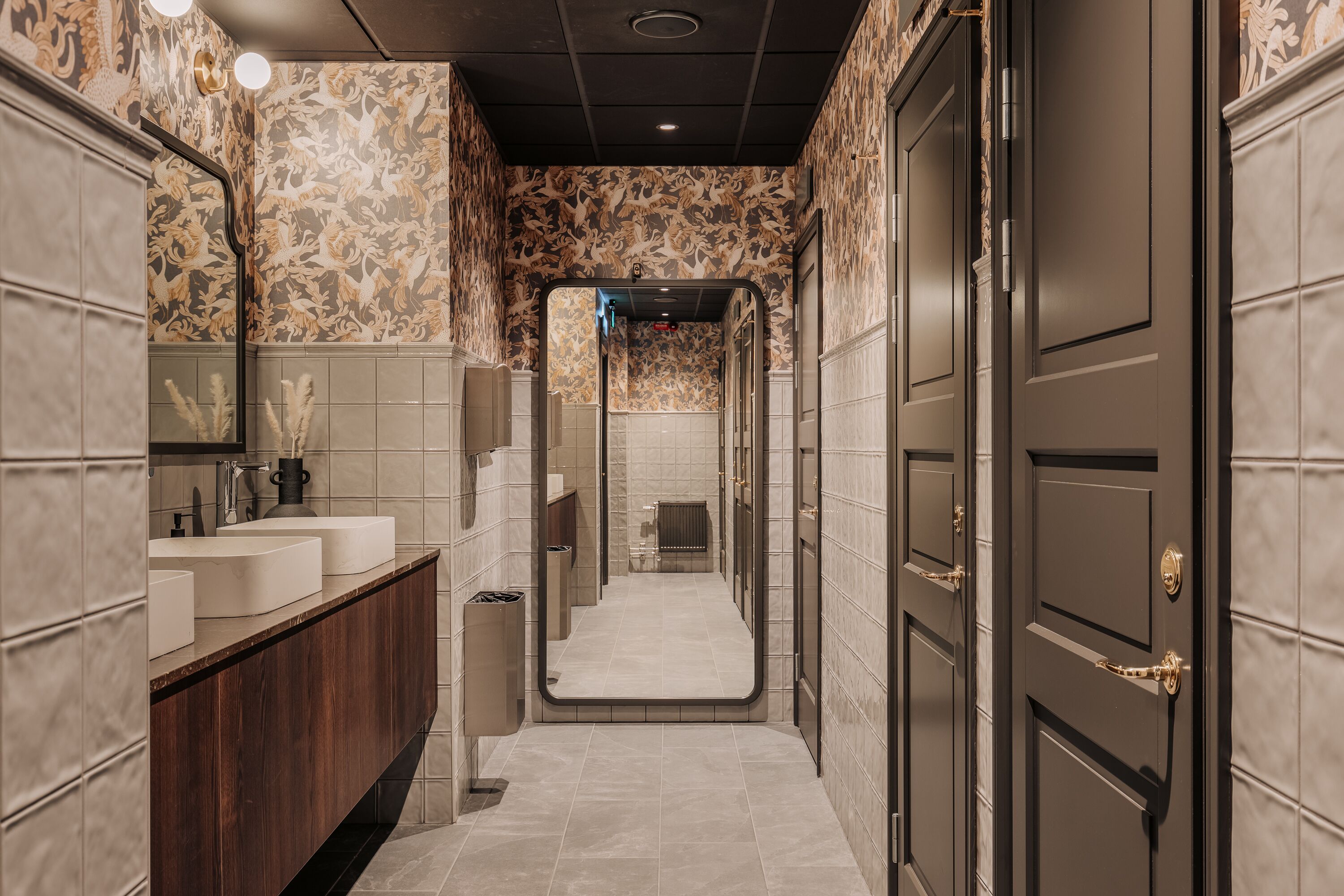 A narrow hallway with a vanity area on the left, a mirror, and a door on the right.