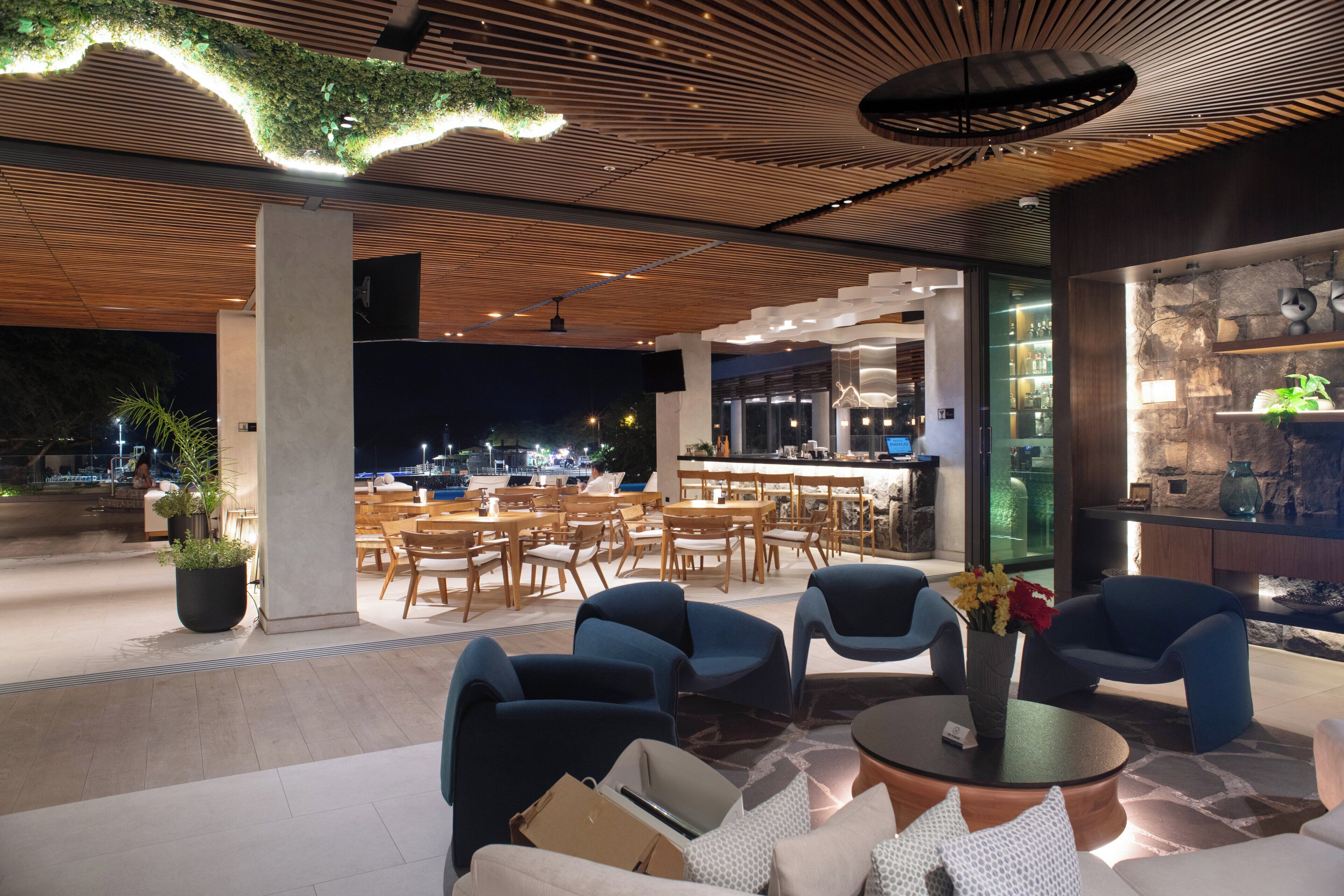 An outdoor seating area with modern furniture and a view of the city at night.
