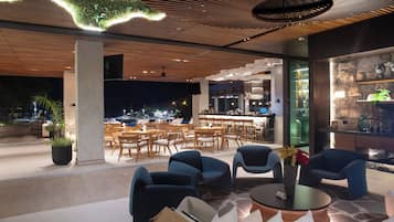 An outdoor seating area with modern furniture and a view of the city at night.