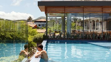 Relax by the serene pool surrounded by lush greenery and modern architecture.