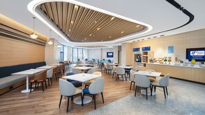 A modern hotel lobby with a central seating area, a reception desk, and a large screen displaying the hotel name. - Holiday Inn Express Xian Quijang Center by IHG (Xi'an)