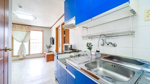 A modern kitchen with a double sink, a stove, and a built-in oven. - Gangchon Pine Hill Pension (Chuncheon)