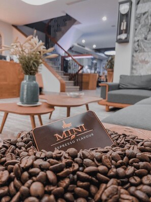 Een presentatie van koffiebonen met een Villiger Mini Espresso Flavour blikje in een modern interieur.