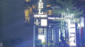 The exterior of Oriana Hotel & Apartment with illuminated signage, a visible entrance, and surrounding greenery. - Oriana Hotel 2 (Hanoi)