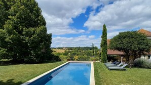 A rectangular swimming pool with a clear blue water surface, surrounded by well-maintained grass and trees. - Studio*** 2 People Heated swimming pool between Châteaux de la Loire and Futuroscope (Rilly-sur-Vienne)