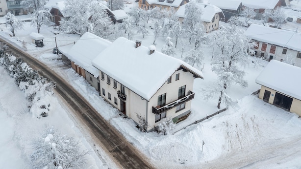A snow-covered residential area with houses and a road. - Cozy pension Sonnenhaus (Gundersheim)