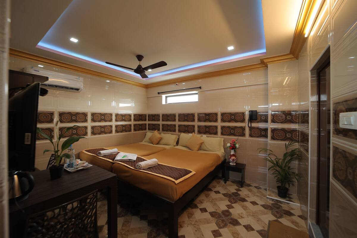 A modern hotel room with a large bed, a desk, and a ceiling fan.