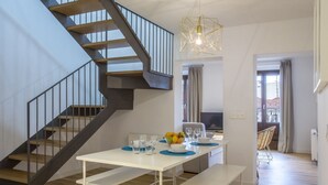 A modern interior with a staircase, dining area, and a view of the outside. - Apartamento Exterior Duplex 4 Dormitorios 2 Baños (Malasaña)