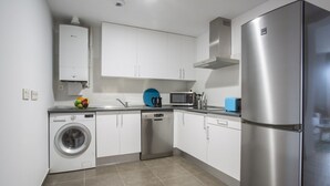 A modern kitchen with white cabinets, stainless steel appliances, and a dishwasher. - Apartamento Exterior Duplex 4 Dormitorios 3 Baños (Malasaña)