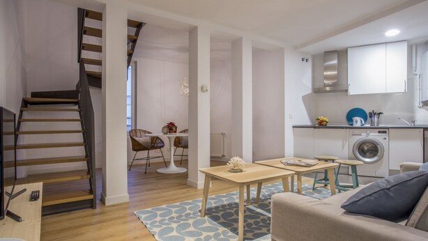 A modern apartment with a staircase, a dining area, a kitchen, and a living room. - Apartamento Interior Duplex 2 Dormitorios 2 Baños (Malasaña)