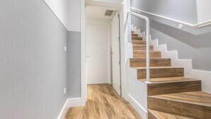 A staircase with wooden steps and white railings, leading to a door at the top. - Apartamento Duplex 2 Dormitorios con Terraza (Madrid)