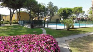 Ett bostadsområde med en swimmingpool, en blomsterrabatt och en gångstig.