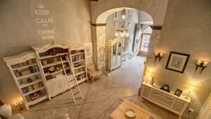 A cozy, well-lit room with a bookshelf, a small table, and a decorative console table with wall sconces.