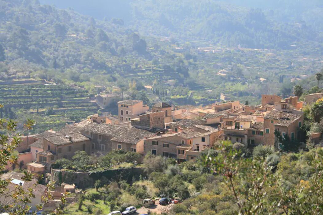 Un borgo rurale con campi a terrazza e edifici tradizionali.