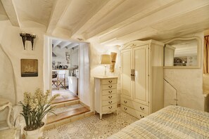 A bedroom with a bed, a dresser, a lamp, and a mirror. - Romantic 1 bed with private patio overlooking orange grove (FORNALUTX)